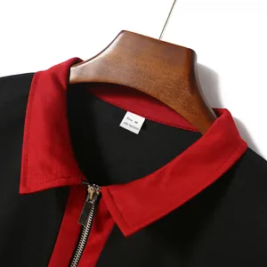 Nahaufnahme von rotem Kragen und Silberreißverschluss am schwarzen Polohemd