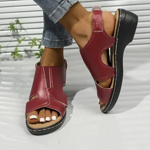 Detailansicht der roten Damensandalen mit Ausschnitten, Klettverschluss und Keilabsatz.