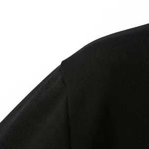 Detailaufnahme des schwarzen, atmungsaktiven Piqué-Stoffs und der Schulternaht eines Poloshirts