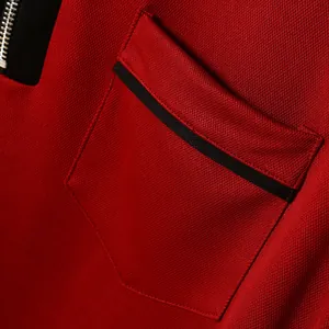 Detailansicht eines roten atmungsaktiven Poloshirts mit Tasche und schwarzem Besatz.