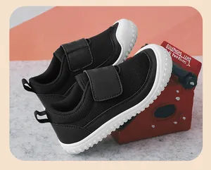 Close-up of black breathable mesh kids sneakers with white sole and Velcro strap