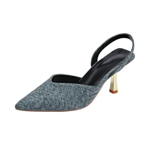 Detailed view of greyish-blue textured pointed toe slingback heels with gold stiletto