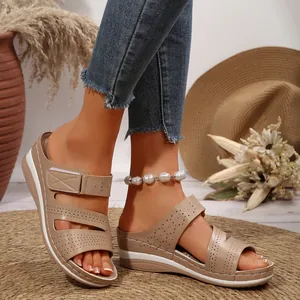 Primo piano di sandali platform kaki con motivi floreali traforati tagliati al laser.