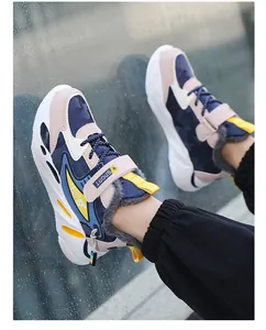Dettaglio scarpe sportive invernali da bambino con fodera in pile e accenti gialli.