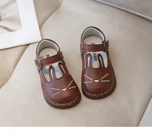 Close-up of brown children's leather shoes with a cute cartoon bunny face design