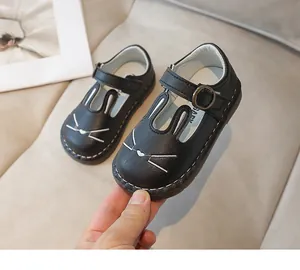 Close-up detail of black children's leather Mary Jane shoes with cute white rabbit embroidery.