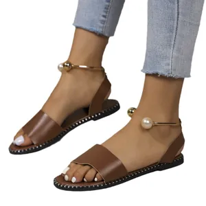 Elegant brown leather flat sandals featuring a gold pearl ankle strap for women