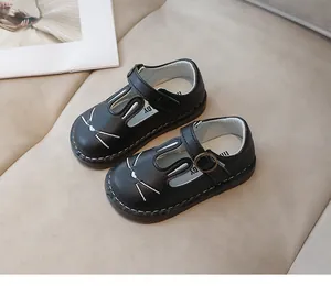 Detail view of cute black cartoon cat-face children's Mary Jane leather shoes with soft soles.