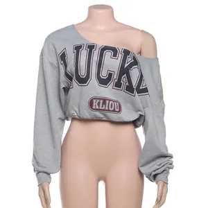 Vista detallada del top corto gris con hombros descubiertos y estampado Lucky mod