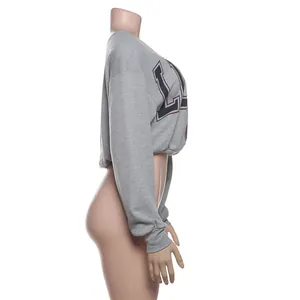 Detalle lateral de camiseta corta gris de manga larga con hombro caído y estampado