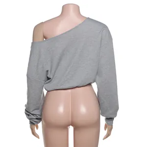 Vista trasera detallada de una camiseta gris de manga larga con hombros al aire