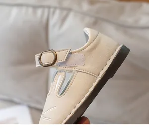 Detail view of beige girl's flats featuring cute rabbit ears and Velcro strap.
