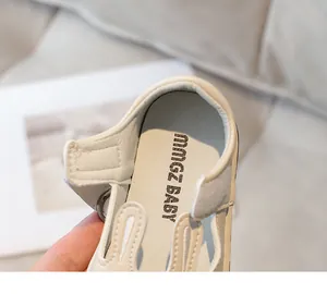 Close-up of cute cream-colored girls' leather shoes with rabbit ear decoration