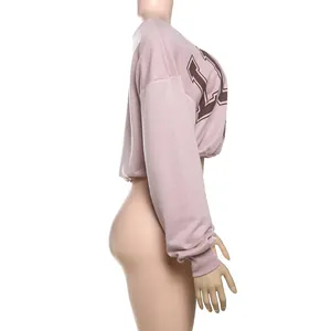 Vista lateral de camiseta corta rosa de manga larga con estampado de letras y hombros
