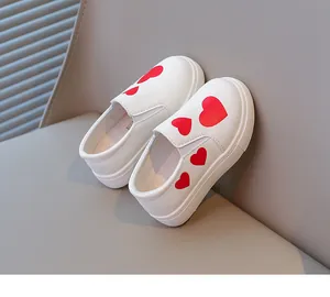 Detail view of stylish white girls' slip-on shoes featuring vibrant red heart patterns
