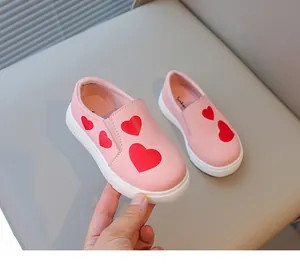 Detail of pink toddler slip-on shoes featuring cute red heart pattern on soft leather