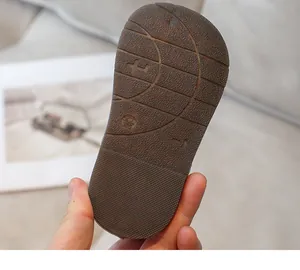 Detailed close-up view of the anti-slip soft rubber sole of a toddler's casual leather shoe.