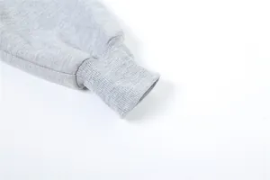 Vista detallada del puño acanalado de una sudadera gris de manga larga con forro polar