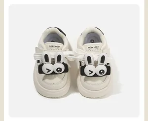 Vista frontale di scarpe da ginnastica crema per bambini con simpatici coniglietti.