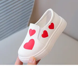 Close-up of white girls' slip-on shoes featuring vibrant red heart patterns