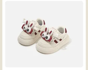Primo piano di scarpe da ginnastica per bambini panna con simpatico coniglio 3D.