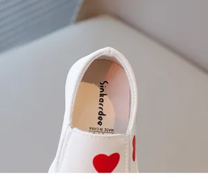 Detail shot of girls white casual leather shoe with red heart pattern insole