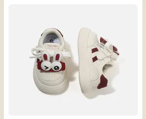 Vista dettagliata di sneaker per bambini color crema con dettagli rossi e coniglio