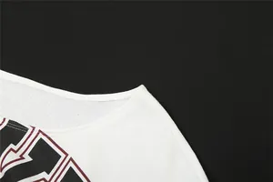 Primer plano del escote y el estampado gráfico en una camiseta blanca de hombros caídos.