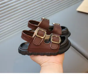 Close-up of brown children's sandals with golden buckles and Velcro straps