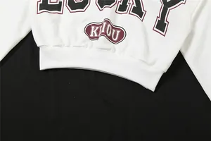 Vista detallada de una camiseta blanca corta de manga larga con estampado de letras y dobladillo.