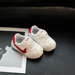 Close-up view of white toddler walking shoes with red swoosh and soft sole