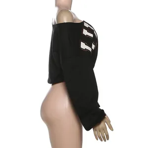 Vista lateral de camiseta negra corta de manga larga con hombros caídos y letras.