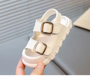 Close-up of white children's sandals with double gold buckles and thick sole