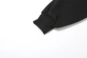 Detalle en primer plano del puño acanalado de una camiseta negra de manga larga.