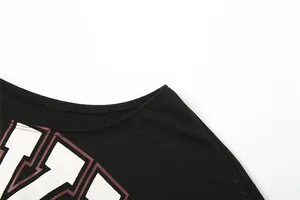 Detalle del cuello con hombros caídos y estampado gráfico en camiseta corta negra