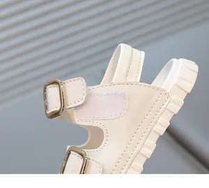 Macro view of white children's sandal showing buckle and velcro strap detail textures
