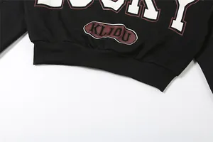 Detalle de camiseta negra corta de manga larga con estampados gráficos KLIOU y LUCKY