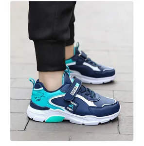 Gros plan de baskets de sport pour garçons bleu marine et sarcelle avec fermetures velcro.