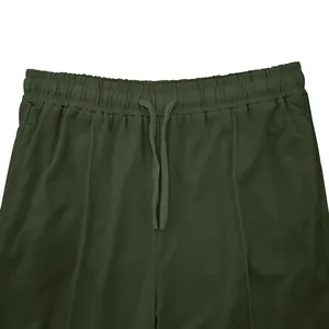 Detalle de la cintura elástica y el cordón de ajuste en los joggers deportivos verde oliva