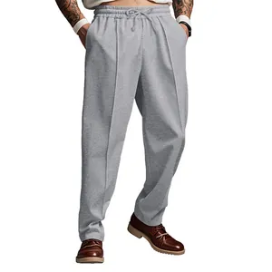 Detalle de pantalones de chándal grises oversize para hombre con pliegues