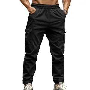 Detail view of men's black tactical cargo pants with large side pockets and elastic waist.