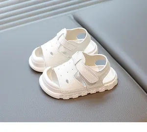 Detail view of white toddler sandals featuring a semi-closed toe and velcro closure