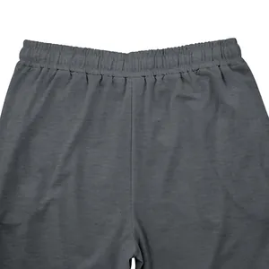Detalle de la cintura elástica en pantalones de chándal grises oversize para hombre