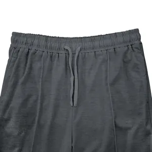 Vista detallada de la cintura elástica con cordón del pantalón de chándal gris para hombre.