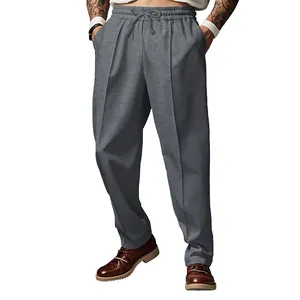 Vista detallada de los pantalones casuales grises oversize para hombre con pliegues.