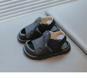 Close-up of black children's sandals featuring soft soles and adjustable velcro straps