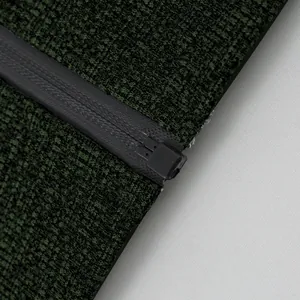 Detailed macro view showing a high-quality zipper on dark green textured fleece fabric.
