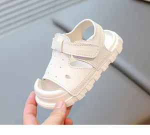 Detail view of white toddler sandals featuring a soft sole and secure velcro strap design