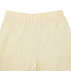 Vista detallada de la cintura elástica de un pantalón de jogging oversize crema para hombre
