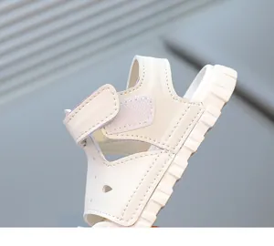 Close-up view of a white toddler sandal featuring a soft sole and adjustable velcro strap